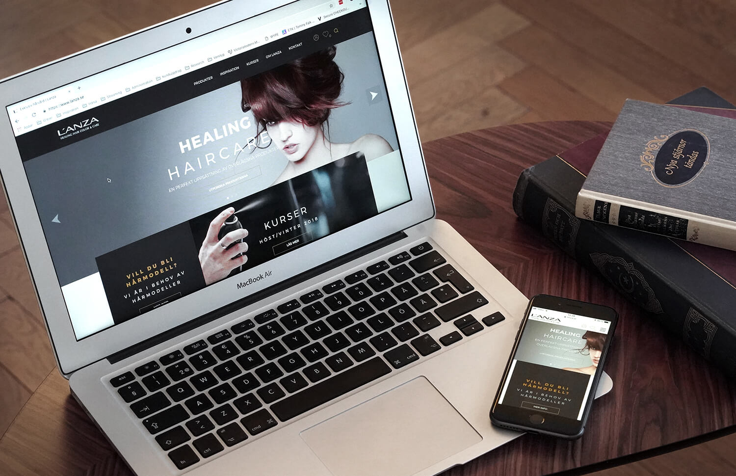 Computer and phone on a desk, showing versions of the lanza.se site.